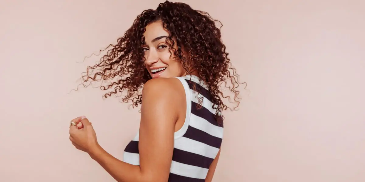 Mulher com cabelo encaracolado a sorrir